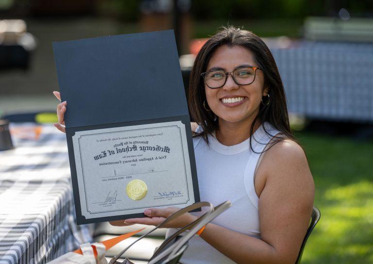 student holding a certificate