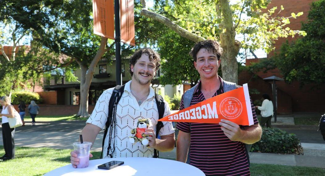 two students holding a sign that says McGeorge